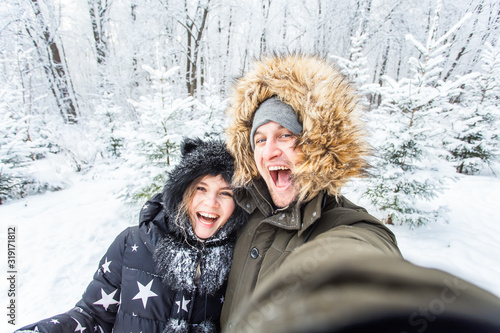 Man taking selfie photo young romantic couple smile snow forest outdoor winter