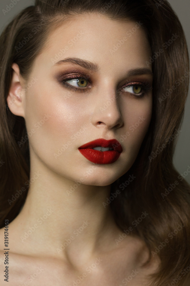 Close-up portrait of the cleanliness face of a beautiful woman with dark black smoky eyes makeup, red full lips. Sexy model with clean shiny skin, clean face, long curly hair. glamorous image Close-up portrait of the cleanliness face of a beautiful woman with dark black smoky eyes makeup, red full lips. Sexy model with clean shiny skin, clean face, long curly hair. glamorous image