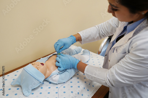 Фотография Performing cpr on a simulation mannequin baby dummy duringing on a simulation ma