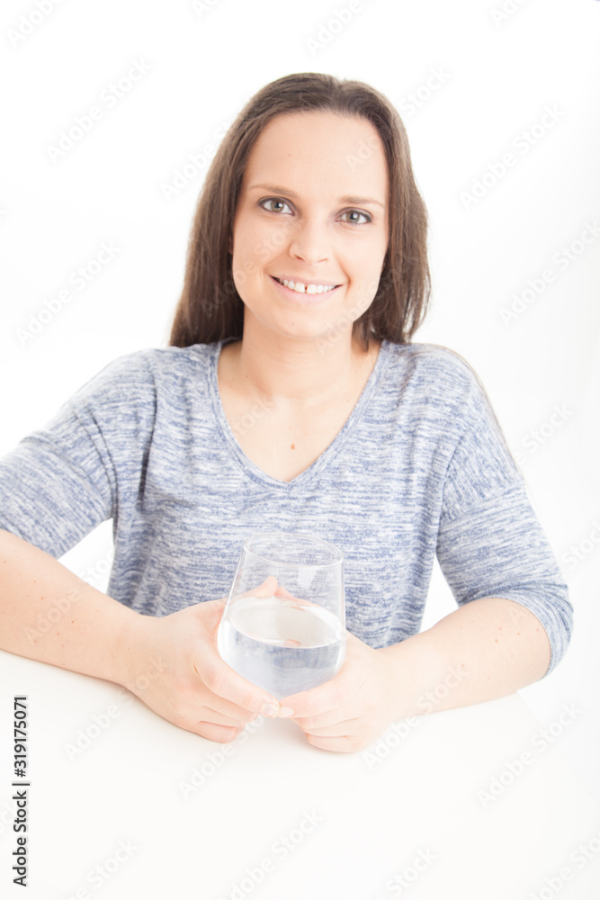Smiling Female drinking or holding glass of water on white background wearing blue top Smiling Female drinking or holding glass of water on white background wearing blue top