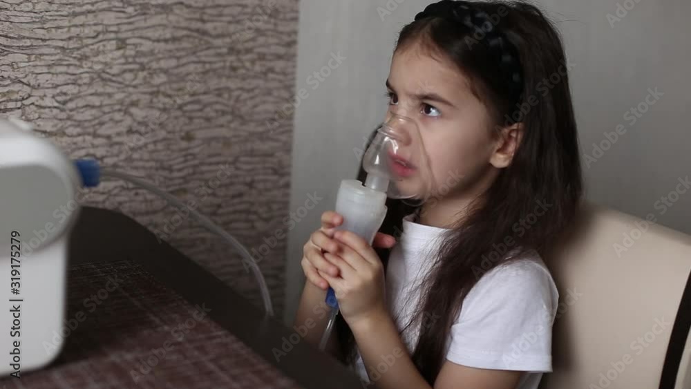 Little brunette girl is being treated with an inhalation Little brunette girl is being treated with an inhalation