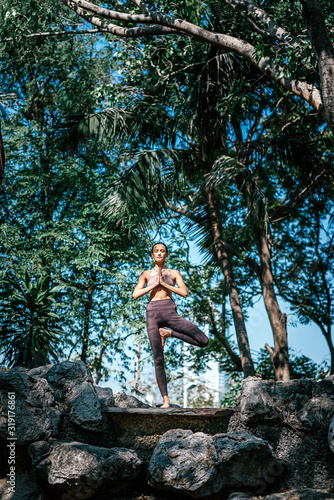 Yoga. For all sizes. For all shapes. Full-length shot of caucasian woman standing in Tree pose, Vrksasana while practicing yoga outdoors, in a garden. Healthy lifestyle and relaxation concept © Adamov