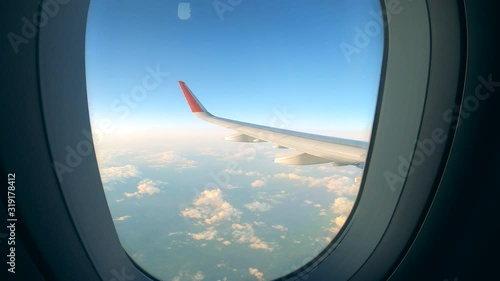 Airplane wing is seen through its window while flying