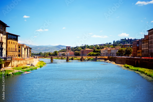 View on old bridge, water of Arno river, blue sky in Florence, Tuscany, Italy in day time in summer. Florence one of the most famous popular touristic city of Italy. View from Uffizi gallery window.