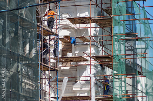 Workers on scaffolding repair building facade