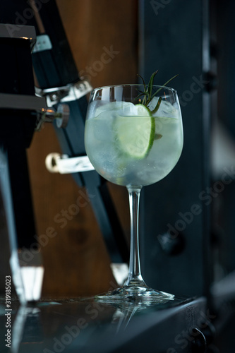 Gin tonic cocktail with rosemary on the background of a bar or restaurant.  Close-up.