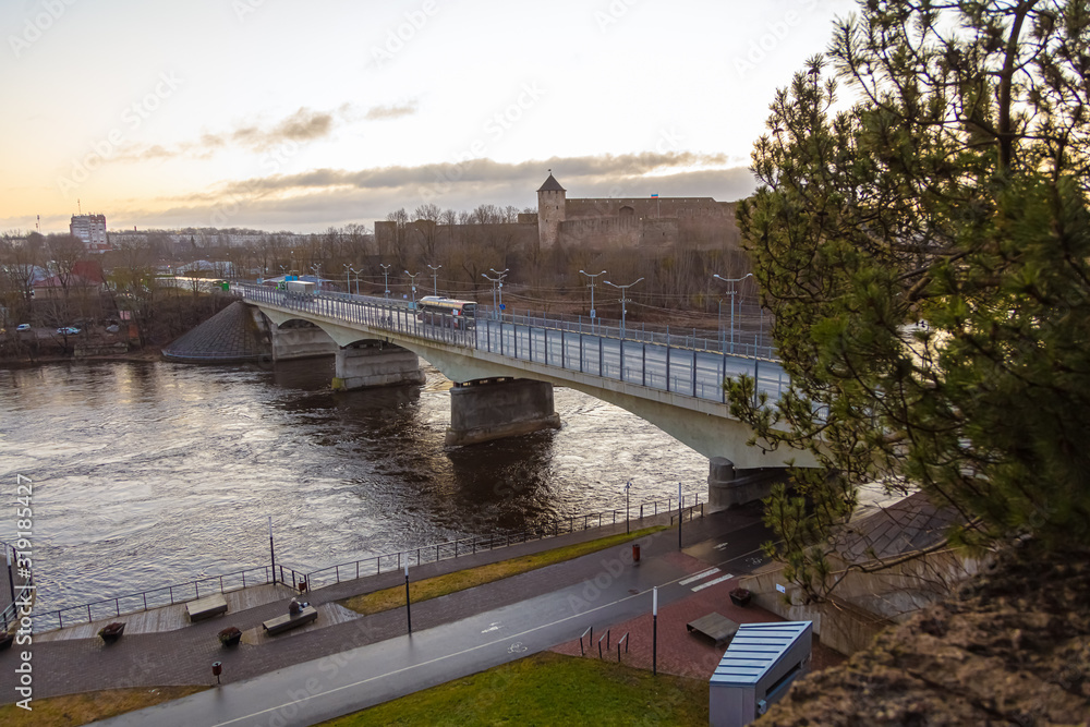 view of the river and landscape under the bridge  Walk under the bridge over the Narova River in the early morning.