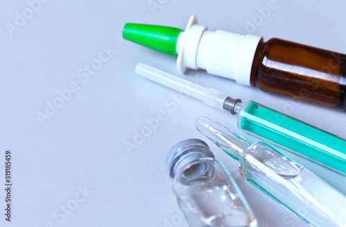 An ampoule with a drug and a disposable syringe for the treatment of pneumonia and coronavirus infection. Development of vaccines and new types of antibiotics. Copy space, close-up, flat lay