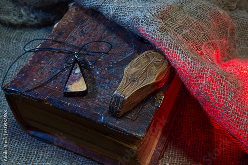 Semiprecious stone. Old book. Wooden doll. Rough fabric. The concept of magic and occultism. photo