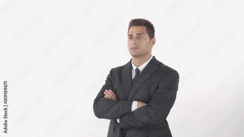 Medium shot of handsome man wearing elegant suit looking aside and crossing arms on his chest while standing on white background Medium shot of handsome man wearing elegant suit looking aside and crossing arms on his chest while standing on white background