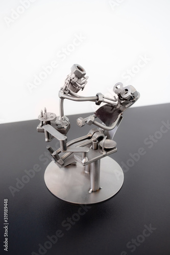 A metal figurine of a dentist and a patient sitting in an armchair. photo