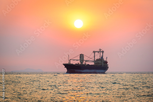 transportation, containers cargo ship out of the Trade Port at sunset