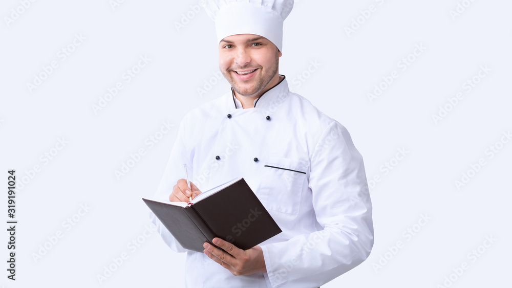 Chef Writing Recipes In Culinary Book Over White Background, Panorama Chef Writing Recipes In Culinary Book Over White Background, Panorama