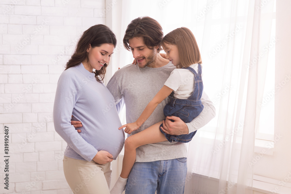 Φωτογραφία Little Girl Touching Mother's Pregnant Belly, Bonding With Parents At Home