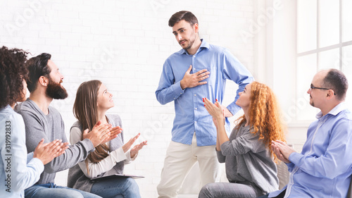 Young man appreciating support at group therapy session in rehab