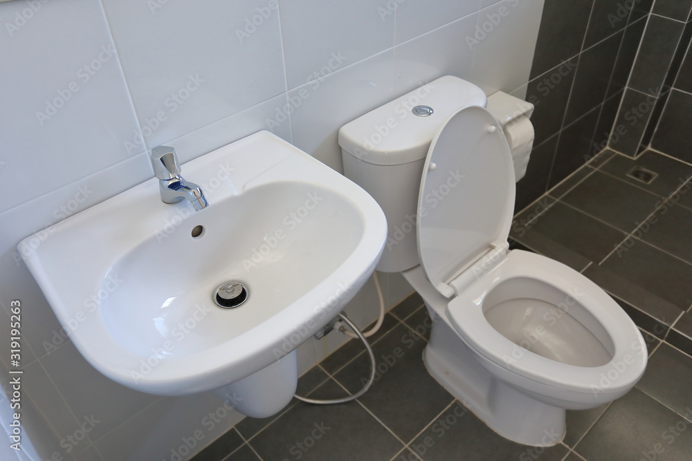 Fototapeta premium modern design of small bathroom with white lavatory water closet and used black tile wall and floor