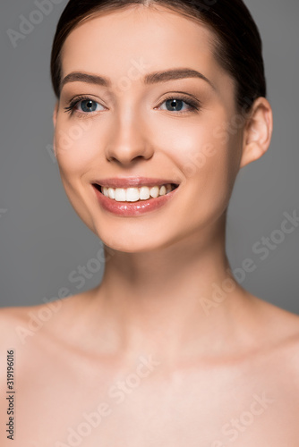 portrait of smiling girl with perfect skin, isolated on grey