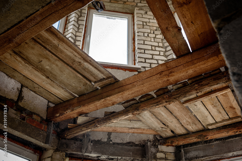 Wooden ceiling beams. Detail of house room interior under construction and renovation. Wooden ceiling beams. Detail of house room interior under construction and renovation.