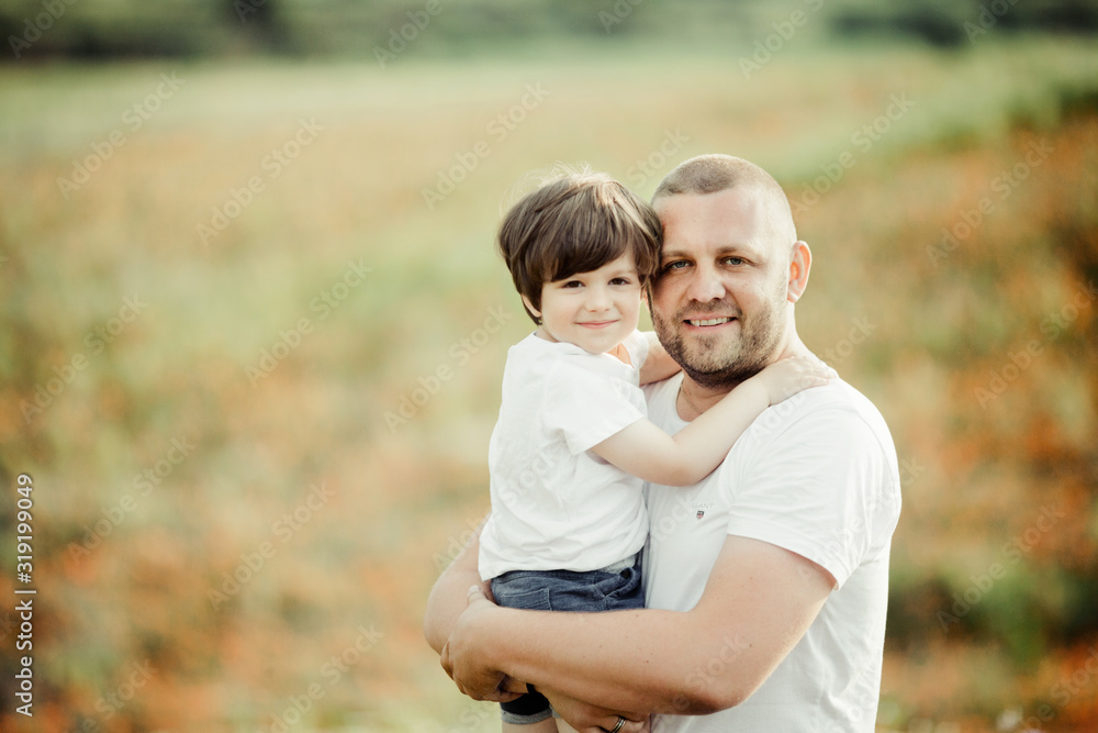 Beautiful portrait of a father with a son, a man is holding a boy on hands