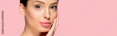 panoramic shot of attractive young woman with perfect skin, isolated on pink