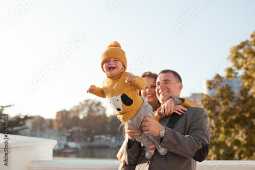 Beautiful happy family on a walk in the autumn park