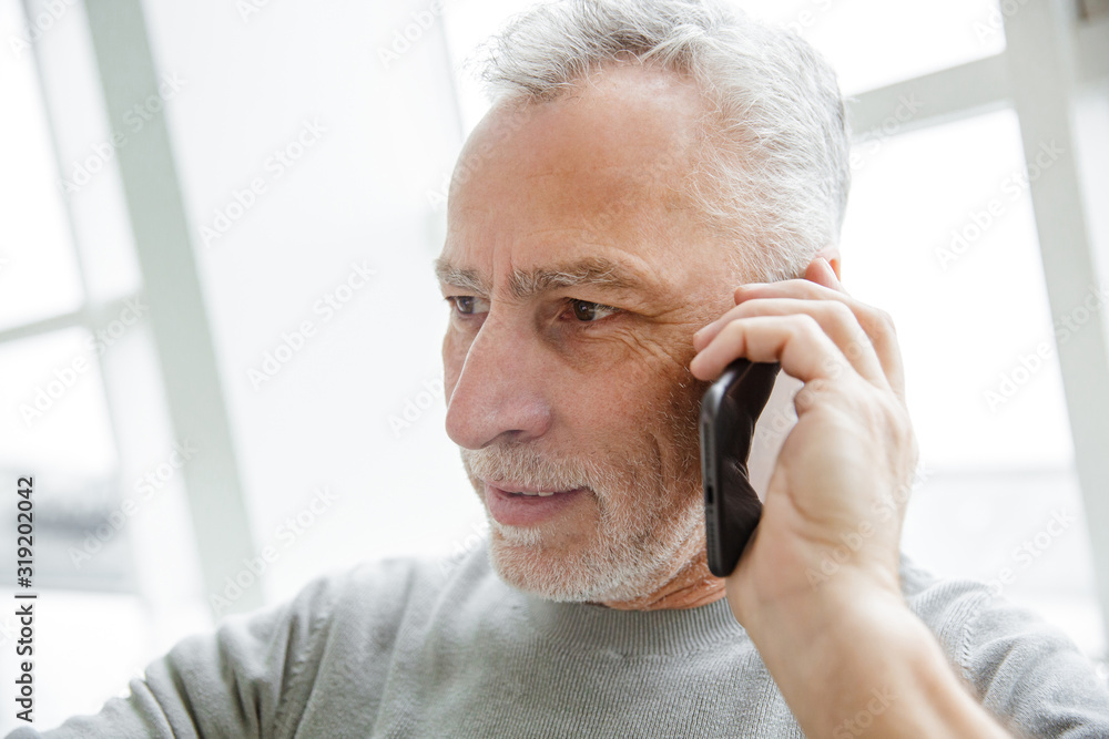 Photo closeup of serious mature man talking on cellphone Photo closeup of serious mature man talking on cellphone