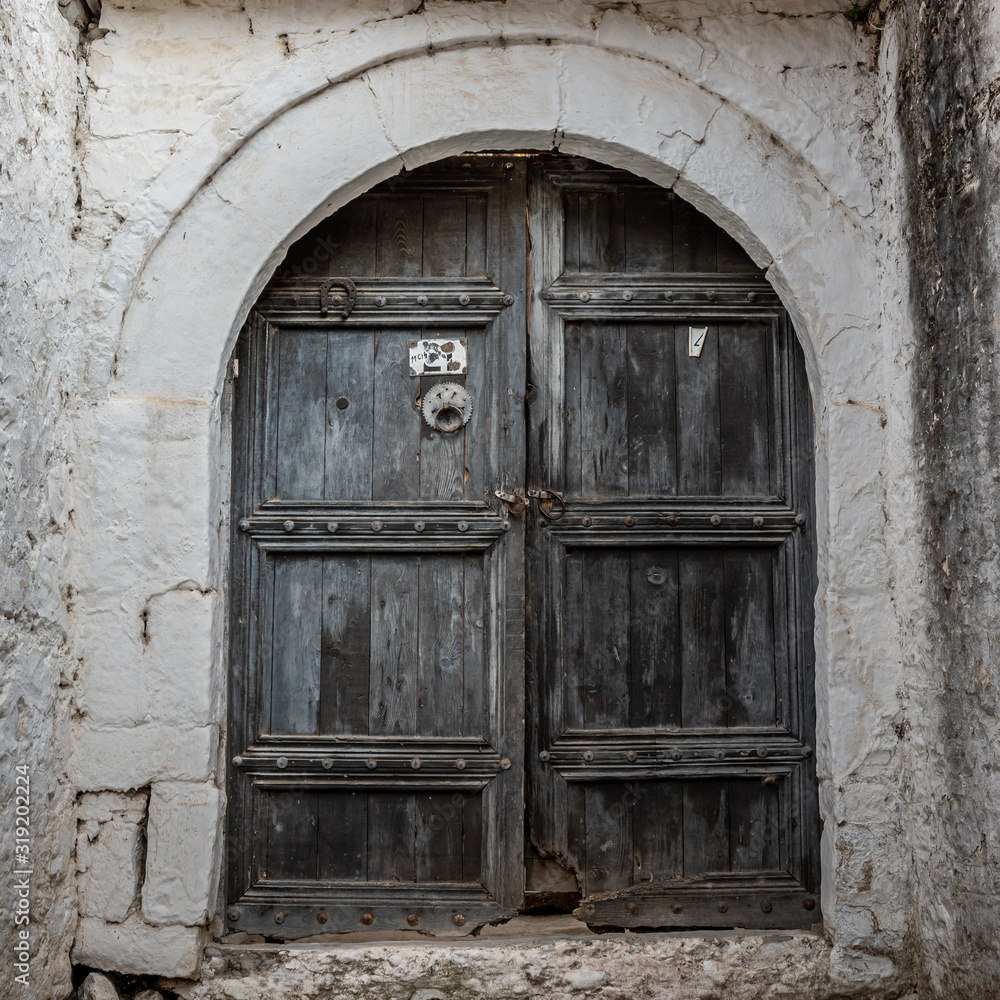 Closed wooden door and stone wall in Berat, Albania