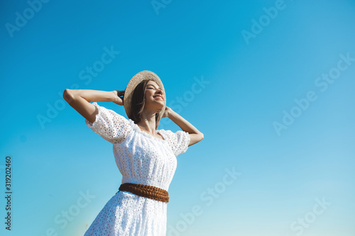 Attractive young woman catching the sunlight. Female outdoors. Lady on wild nature. Freedom.