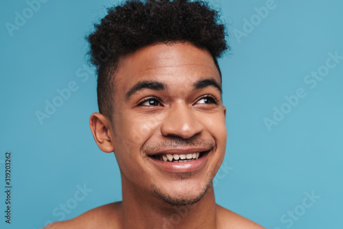 Photo of joyful african american man laughing and looking aside