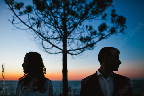 Billede på lærred Couple standing separately and looking in different sides near picturesque lonel
