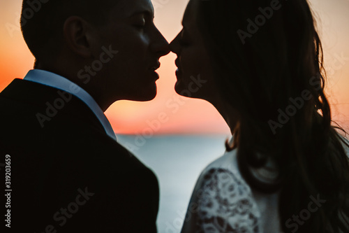 Silhouette of a couple a moment before kiss by the sea on the wedding day