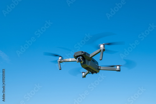 Fototapeta Naklejka Na Ścianę i Meble -  Folding drone flying in blue sky