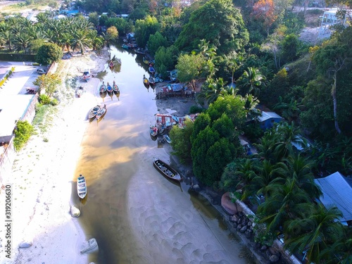 Panoramic View of Patong Beach buildings boats parasailing jetski people on the beach and beautiful blue skies long tail boats photo