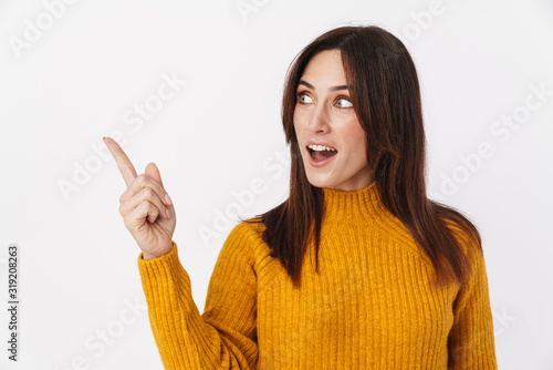 Image of adult woman smiling and pointing finger aside at copyspace