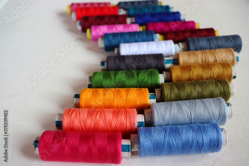 colorful spools of sewing thread on a white background