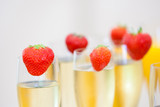 Glasses of sparkling wine or champagne and strawberry on a blurry background during some sort of festivity or celebration such as a wedding, borthday or newyear