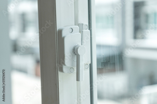 Window lock handle of modern home looking outside the house.