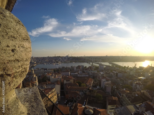 Sunset from above Galata tower, city buildings under, bridges crossing over Bosphorus strait photo