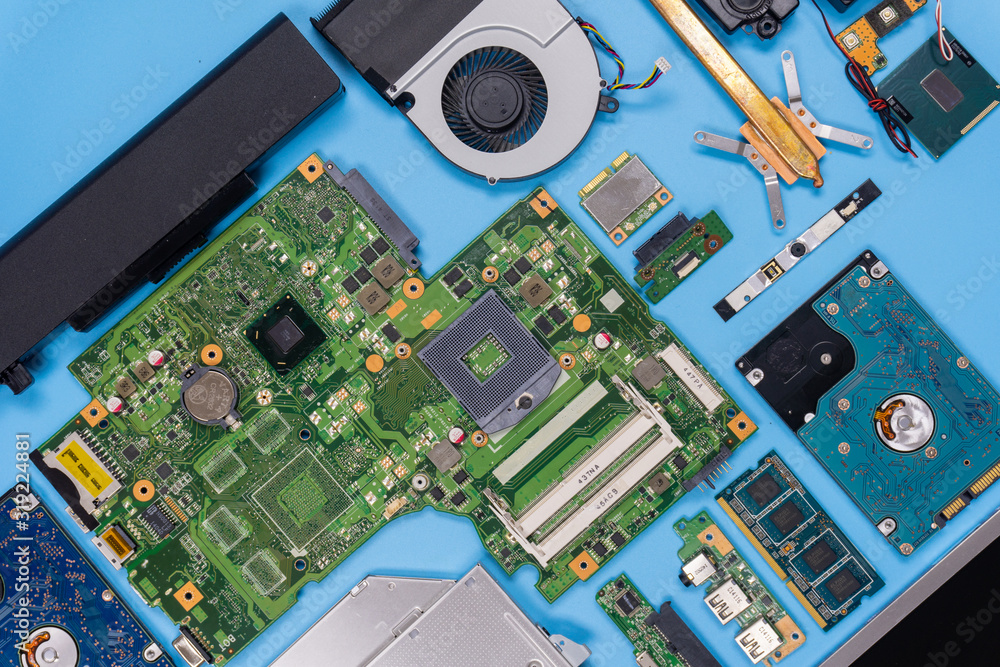 Parts of a modern computer. The insides of a laptop on a blue background, flat lay composition Parts of a modern computer. The insides of a laptop on a blue background, flat lay composition