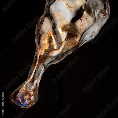 Colorful creative amorphous soap bubble floating with a black background