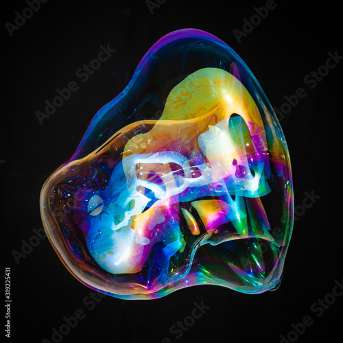 Colorful creative amorphous soap bubble floating with a black background
