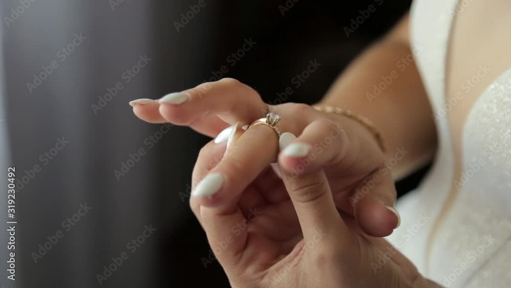 Picture of beautiful female barefoot legs in wedding dress. Bride dresses stockings on feet. Bride putting a wedding garter on her leg. Picture of beautiful female barefoot legs in wedding dress. Bride dresses stockings on feet. Bride putting a wedding garter on her leg.