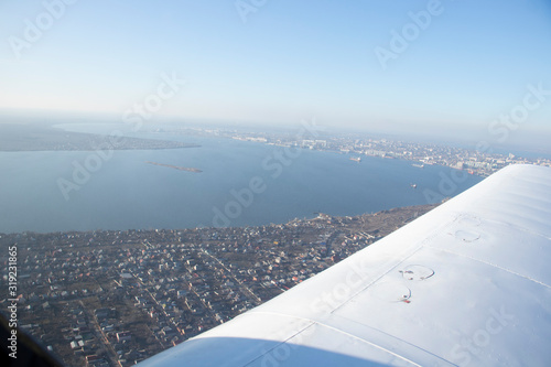 Aerial view of the city. Foggy day, sunny weather and blue sky. 400 meters above the ground. Small houses and river view. Winter sky.