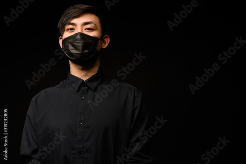 Asian man with medical face mask to protection the coronavirus. Young Asian man living in city with polluted air