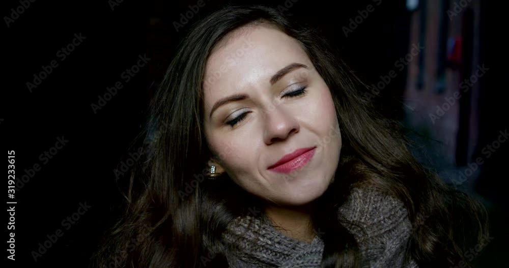 close-up of the face of a brunette with long hair and bright lipstick on her lips. the girl stares at the camera and smiles close-up of the face of a brunette with long hair and bright lipstick on her lips. the girl stares at the camera and smiles