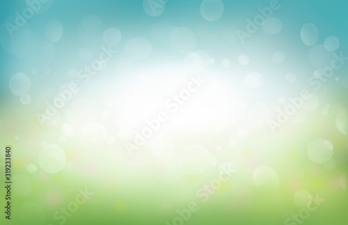 A spring background of blue and green, blurred foilage and sky with bright bokeh. photo