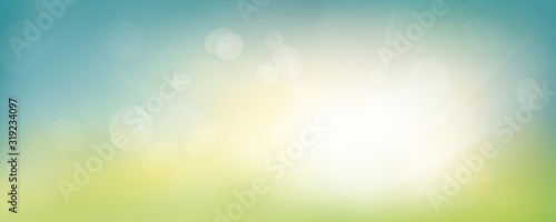 A fresh spring blue sunny sky background with blurred warm sunny glow. #319234097