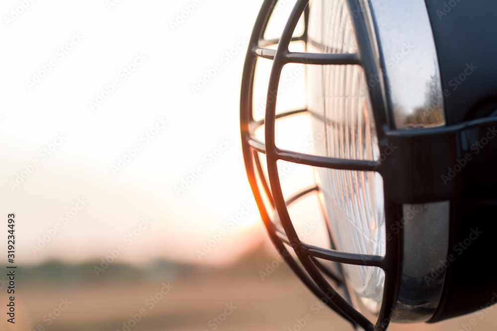 Close-up of motorcycle headlight on sunset background. Close-up of motorcycle headlight on sunset background.