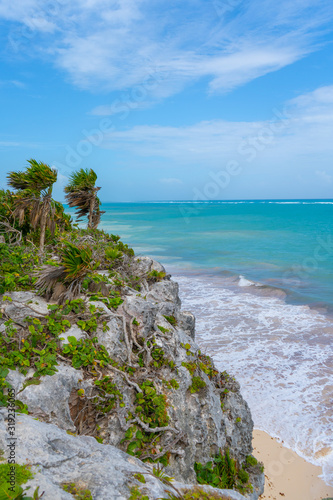 Caribbean coast near Tulum. Turquoise sea and blue sky. Nature with rocks and plants. Travel photo, background. Yucatan. Quintana roo. Mexico.