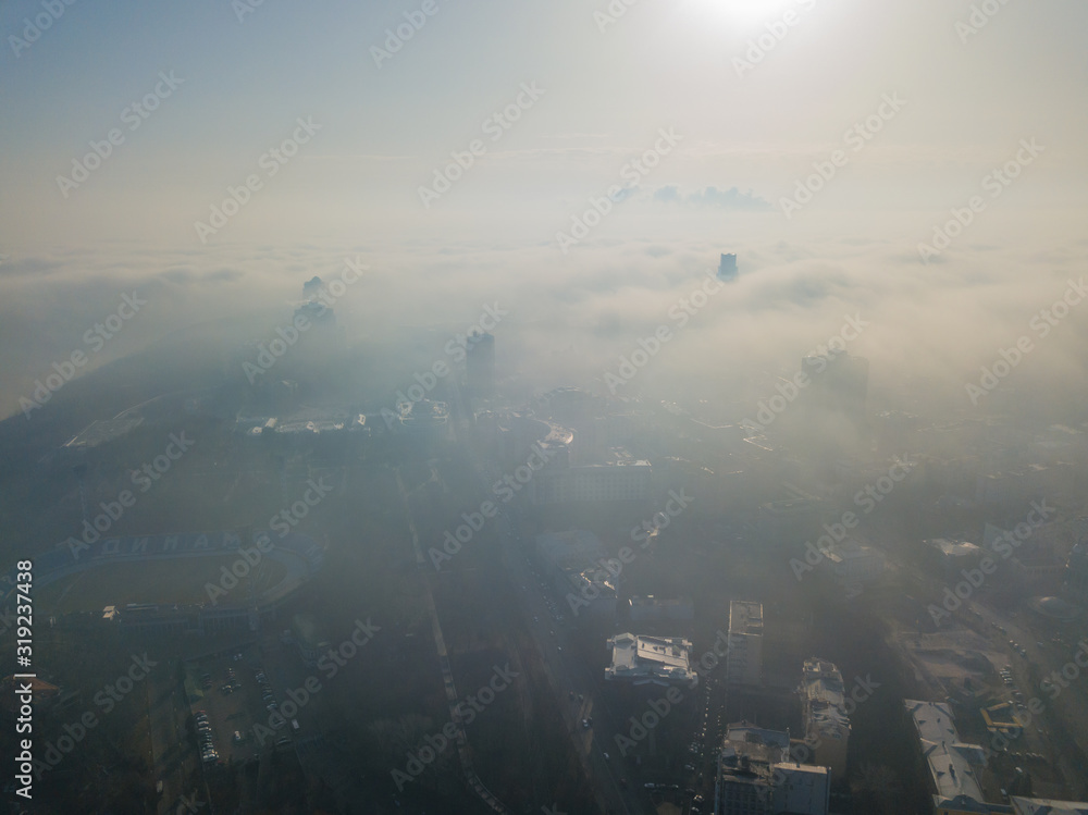 Aerial drone view. A foggy morning in Kiev, the silhouettes of houses are visible through the autumn fog. Aerial drone view. A foggy morning in Kiev, the silhouettes of houses are visible through the autumn fog.
